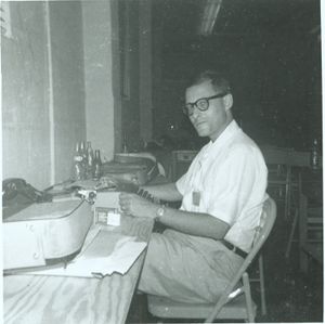 Reporter sitting at a typewriter inside the press room at the University of Alabama in Tuscaloosa.