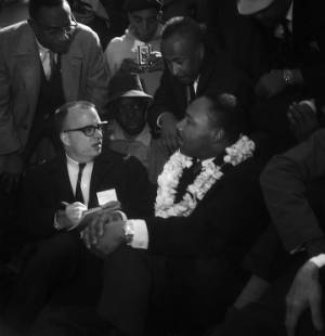 Martin Luther King Jr. speaking with Hugh Merrill, journalist for the Huntsville Times, at the first rest stop on the Selma to Montgomery March, two miles outside of Selma, Alabama.
