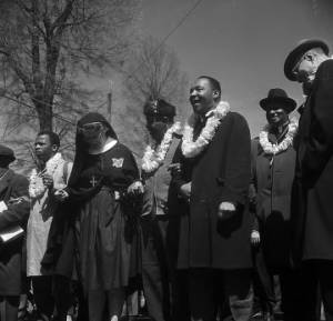 John Lewis, Ralph Abernathy, Martin Luther King Jr., Ralph Bunche, and others standing in a line on Sylvan Street in downtown Selma, Alabama, before the start of the Selma to Montgomery March.