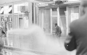 Firemen spraying civil rights demonstrators with fire hoses in downtown Birmingham, Alabama.