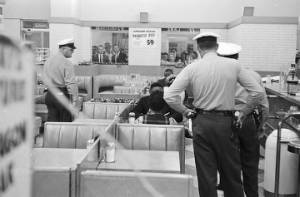 Police officers confronting African Americans engaged in a sit-in at either Lane Drugs or Tutwiler Drug in Birmingham, Alabama.
