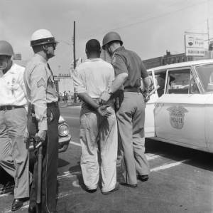 Firemen spraying a civil rights demonstrator with a hose during the Children's Crusade in downtown Birmingham, Alabama.