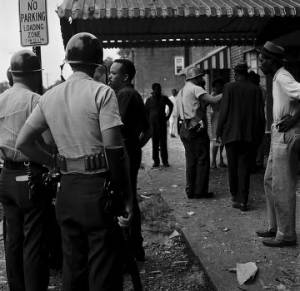 Police officers and bystanders in front of Social Cleaners across from 16th Street Baptist Church, after the church was bombed.