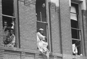 African Americans looking through windows that were blown out during the bombing of 16th Street Baptist Church in Birmingham, Alabama.