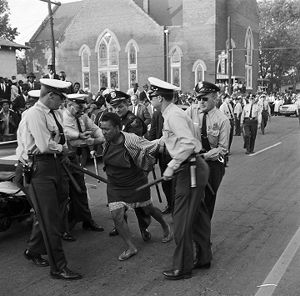 Police officers arresting an African American woman during a civil rights demonstration on 6th Avenue North in Birmingham, Alabama.