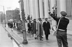 Fred Shuttlesworth and other civil rights demonstrators standing before a police officer during a protest march in downtown Birmingham, Alabama.