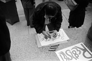 Demonstrator making a sign for a voter registration rally outside the Jefferson County courthouse in Birmingham, Alabama.
