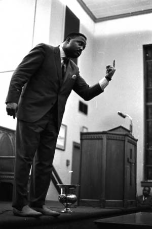 Hosea Williams speaking at a meeting in a church building.