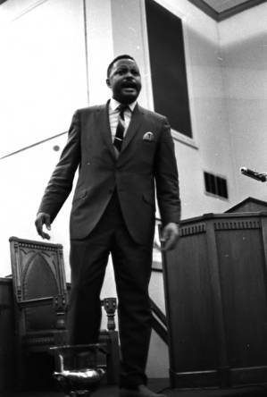 Hosea Williams speaking at a meeting in a church building.