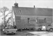 People entering a wooden church building in rural Prattville, Alabama, for a meeting.