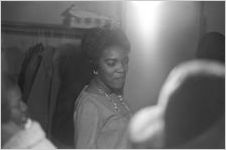 Woman standing in a crowd beside the coat closet at Hall Street Baptist Church in Montgomery, Alabama.