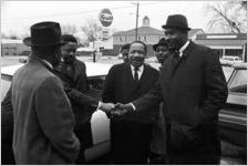 Hosea Williams, Martin Luther King, Jr., and other men, standing in the parking lot outside Tabernacle Baptist Church in Selma, Alabama.