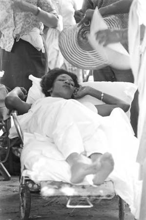 Woman lying on a stretcher during a civil rights demonstration in Greensboro, Alabama.