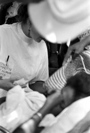 Woman from the Medical Committee for Human Rights, attending to a woman on a stretcher during a civil rights demonstration in Greensboro, Alabama.