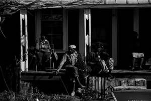 People seated on the porch of a house near Harrison Street Baptist Church in Greenville, Alabama, before a meeting.
