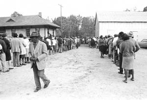 Lines of people standing outside buildings in Lowndes County, Alabama, on election day.