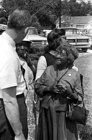 Man talking to women while standing in line on election day in Lowndes County, Alabama.