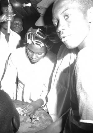 Young woman writing on a slip of paper while standing outdoors at a civil rights demonstration in Montgomery, Alabama.