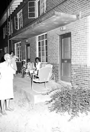 Women on the porch and in the yard outside apartments at Cleveland Court in Montgomery, Alabama, during a civil rights rally.