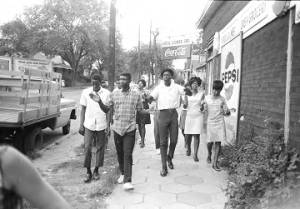 Group marching down a sidewalk in downtown Montgomery, Alabama, during a civil rights demonstration.