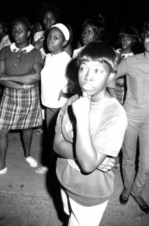 Young women standing in front of an apartment building at Cleveland Court in Montgomery, Alabama, listening to Idessa Williams speak during a civil rights rally.