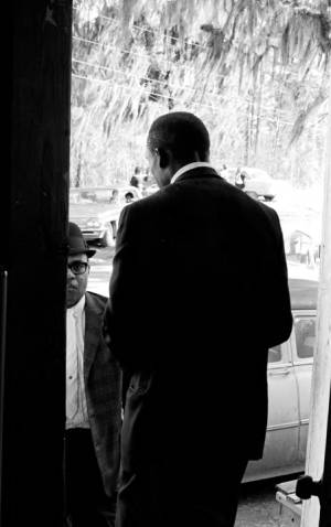 John Hulett speaking to another man from the doorway of Mt. Moriah Baptist Church in Hayneville, Alabama, during the first anniversary celebration of the Lowndes County Christian Movement.