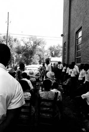 Stokely Carmichael addressing a group of people standing outside the First Missionary Baptist Church in Prattville, Alabama, during a meeting of the Autauga County Improvement Association.