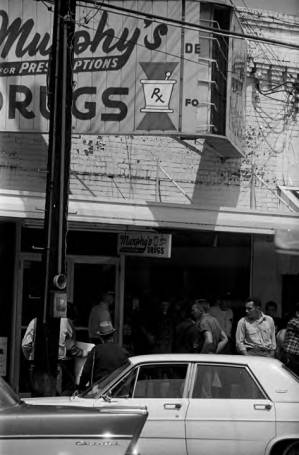 Protestors carrying signs while marching past Murphy's Prescription Drugs in downtown Prattville, Alabama, during a civil rights demonstration.