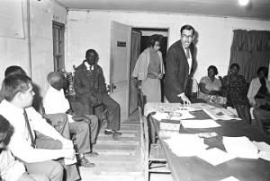 Man addressing an audience at the office of the Autauga County Improvement Association in Prattville, Alabama.