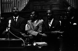 P. H. Lewis, F. D. Reese, and others, linking arms and singing behind the podium at Brown Chapel AME Church in Selma, Alabama.