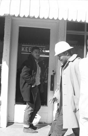 Wendell Paris and other students from Tuskegee Institute marching down a sidewalk during a demonstration to protest the murder of Samuel L. Younge, a civil rights worker.