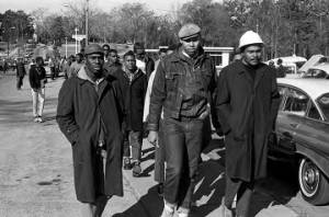 Wendell Paris and other students from Tuskegee Institute marching down a sidewalk on Old Montgomery Road during a demonstration to protest the murder of Samuel L. Younge, a civil rights worker.