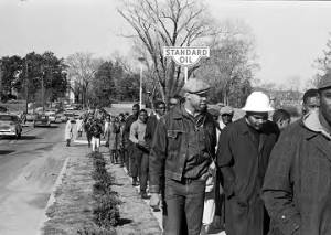 Wendell Paris and other students from Tuskegee Institute marching down a sidewalk on Old Montgomery Road during a demonstration to protest the murder of Samuel L. Younge, a civil rights worker.