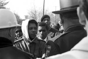 Simuel Schutz, Jr., and other students speaking to policemen who have lined up across Old Montgomery Road to block their demonstration in Tuskegee, Alabama, to protest the murder of Samuel L. Younge, a civil rights worker.