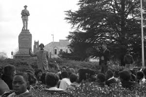 Dr. Frank Toland addressing a crowd seated in front of the Confederate monument in Tuskegee, Alabama, during a student demonstration to protest the murder of Samuel L. Younge, a civil rights worker.