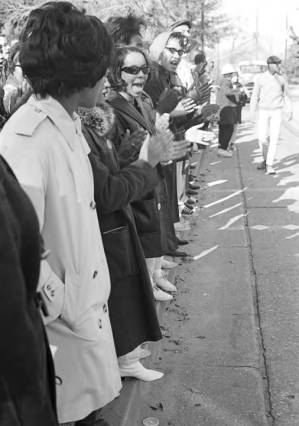 Students from Tuskegee Institute lined up along a street during a demonstration to protest the murder of Samuel L. Younge, a civil rights worker.