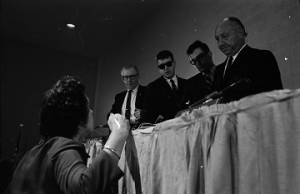 Woman speaking to Senators George Murphy and Jacob Javits before or after a hearing held by the Senate Subcommittee on Employment, Manpower, and Poverty at the Heidelberg Hotel in Jackson, Mississippi.