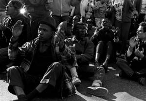 Students from Tuskegee Institute seated on a road during a demonstration to protest the murder of Samuel L. Younge, a civil rights worker.