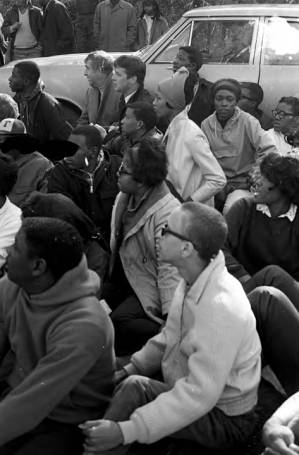 Students from Tuskegee Institute seated on a road during a demonstration to protest the murder of Samuel L. Younge, a civil rights worker.