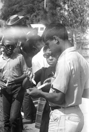 Young woman and man lighting candles during a demonstration by Tuskegee Institute students, to protest the verdict in the trial of Thomas Coleman, a Lowndes County man who had been charged with the murder of Jonathan Daniels.