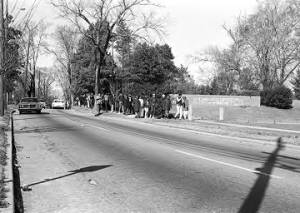 Students from Tuskegee Institute marching down a sidewalk on Old Montgomery Road during a demonstration to protest the murder of Samuel L. Younge, a civil rights worker.