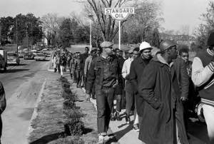 Wendell Paris and other students from Tuskegee Institute marching down a sidewalk on Old Montgomery Road during a demonstration to protest the murder of Samuel L. Younge, a civil rights worker.
