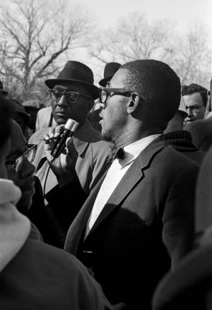 Dr. Burcham Phillips speaking into a microphone during a student demonstration in Tuskegee, Alabama, to protest the murder of Samuel L. Younge, a civil rights worker.