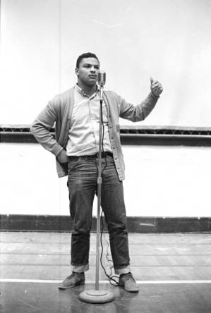 Wendell Wilkerson speaking during a meeting in the Tuskegee Institute gymnasium, which was held to discuss student demonstrations protesting the murder of Samuel L. Younge.
