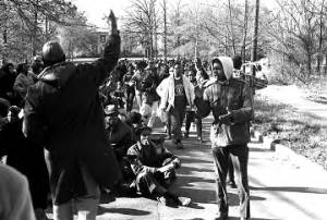 Students from Tuskegee Institute seated on a road during a demonstration to protest the murder of Samuel L. Younge, a civil rights worker.