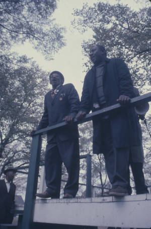 Albert Turner and other men standing on a platform during a rally at Kelly Ingram Park in in Birmingham, Alabama, protesting the incarceration of Martin Luther King, Jr., and several other civil rights leaders.