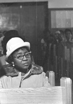 Woman sitting in an audience at Maggie Street Baptist Church in Montgomery, Alabama, probably listening to Martin Luther King, Jr., speak.