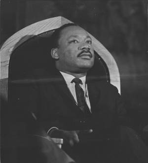 Martin Luther King, Jr., seated behind the speaker during a meeting at St. Paul AME Church in Birmingham, Alabama.