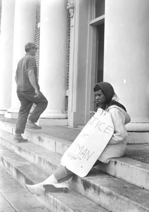 Young woman seated on the steps in front of the Barbour County courthouse in Eufaula, Alabama.