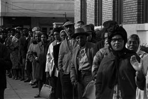Men and women standing in line outside a courthouse in Birmingham, Alabama, during a voter registration drive.